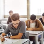 Teens take an exam at school.